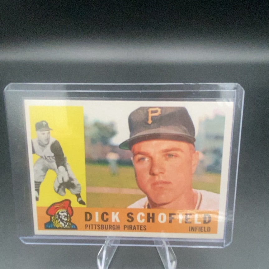 1960 Topps Baseball Card #104 featuring infielder Dick Schofield: This is a 1960 Topps baseball card featuring Pittsburgh Pirates player Dick Schofield. The card showcases a portrait of Schofield alongside a smaller action shot of him in the field.