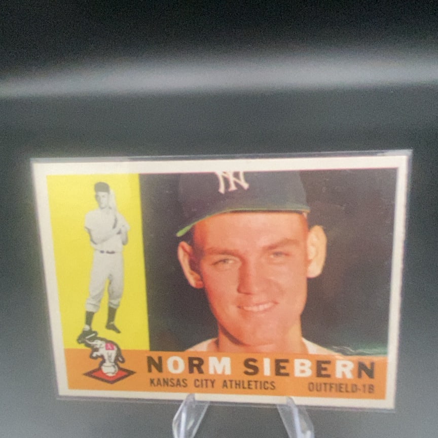 1960 Topps #11 Norm Siebern baseball card: This is a 1960 Topps baseball card featuring Norm Siebern of the Kansas City Athletics. The card is displayed in a protective sleeve and shows a close-up portrait along with a full-length photo of