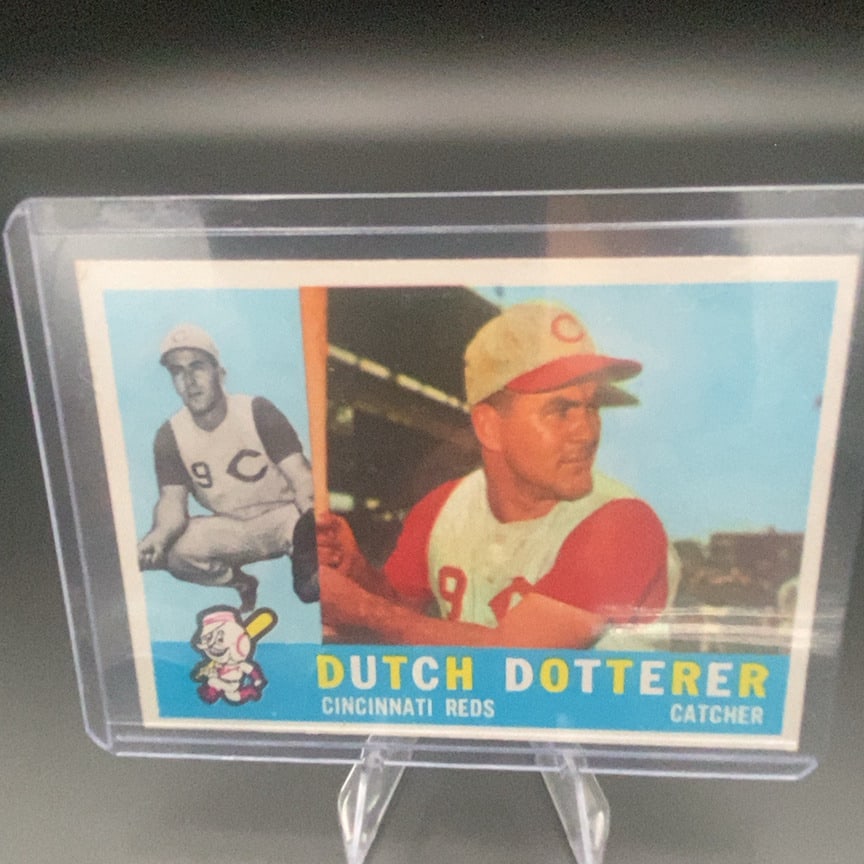 1960 Topps #21 Dutch Dotterer Cincinnati Reds Baseball Card: This is a baseball card featuring Dutch Dotterer of the Cincinnati Reds. The card shows his name, team, and position as a catcher.