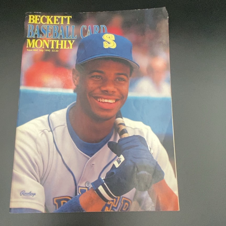 1990 Beckett Baseball Card Monthly Ken Griffey Jr: This is an issue of Beckett Baseball Card Monthly, specifically Issue #64 from July 1990. The cover features a photograph of baseball player Ken Griffey Jr. in his Seattle Mariners uniform.