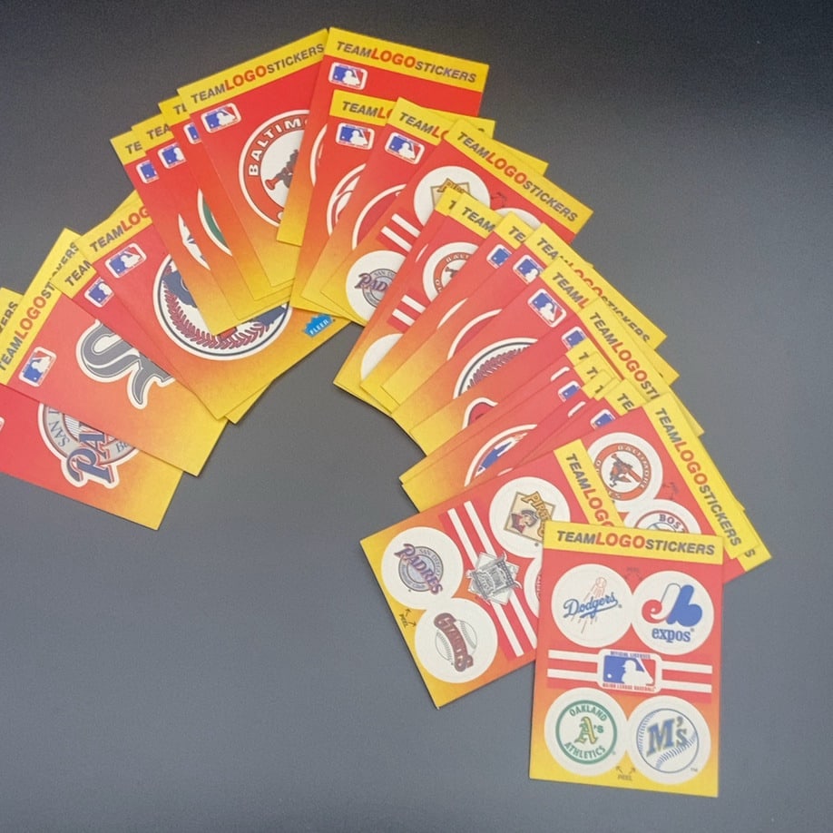 Fleer Team Logo Stickers (front): A collection of Fleer Major League Baseball team logo sticker sheets. The stickers feature various team logos and branding from the MLB, including teams like the Dodgers, Expos, Athletics, and