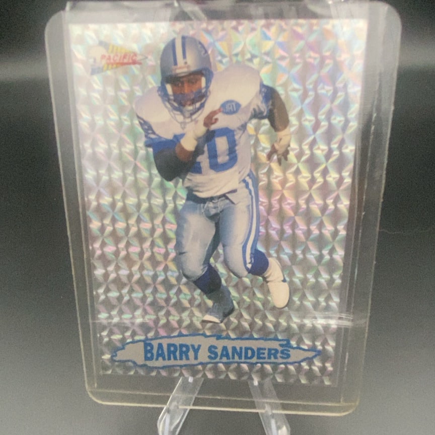 1992 Pacific Prism Barry Sanders (Insert #7 of 10: This is a trading card featuring Detroit Lions running back Barry Sanders. The card is produced by Pacific and features a distinct prismatic holographic background pattern. The player is shown in his