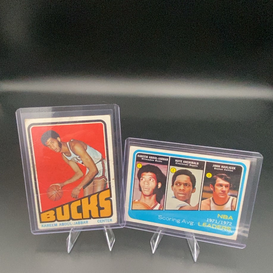 1972–73 Topps basketball trading cards featuring Hall of Famer Kareem Abdul-Jabbar: This lot features two vintage 1972-73 Topps basketball cards. It includes a Kareem Abdul-Jabbar Milwaukee Bucks card and a 1971-72 NBA Scoring Average Leaders card featuring Kareem Abdul-Jabbar, Nate