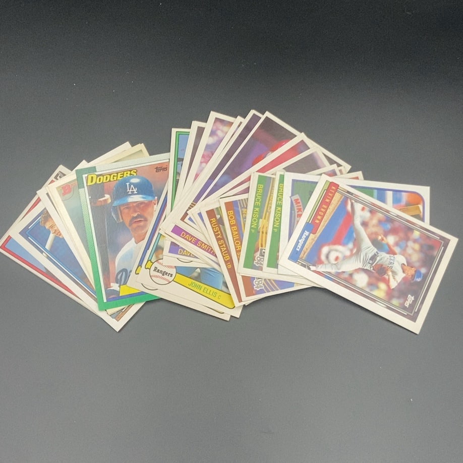 Mixed 1980s Topps Baseball Card Lot: This is a collection of mixed vintage Topps baseball cards from the 1980s. The stack features various players including Kevin Brown, Bruce Kison, Bob Bailor, Rusty Staub, and John Ellis. These