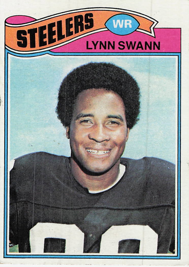 1977 Topps #195 Lynn Swann football trading card: 1977 Topps Football Lynn Swann #195 is a base trading card featuring Lynn Swann during his tenure with the Pittsburgh Steelers. This vintage Topps issue spotlights Swann as one of the Steelers'