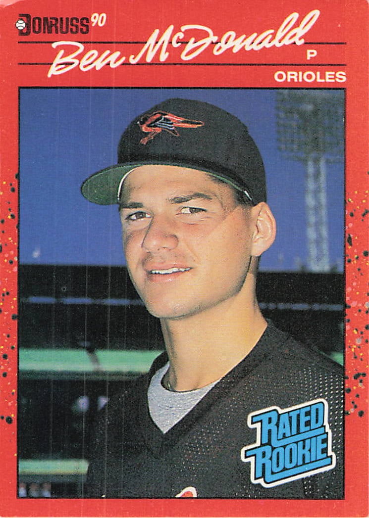 1990 Donruss Rated Rookie Ben McDonald baseball card: This is a 1990 Donruss baseball card featuring pitcher Ben McDonald of the Baltimore Orioles. The card is marked with the iconic Rated Rookie logo.