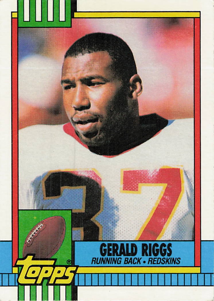 1990 Topps football trading card featuring running back Gerald Riggs: 1990 Topps Gerald Riggs #122 is a base trading card featuring Gerald Riggs during his tenure with the Washington Redskins. Issued during the Junk Wax era, the 1990 Topps football set presents veteran