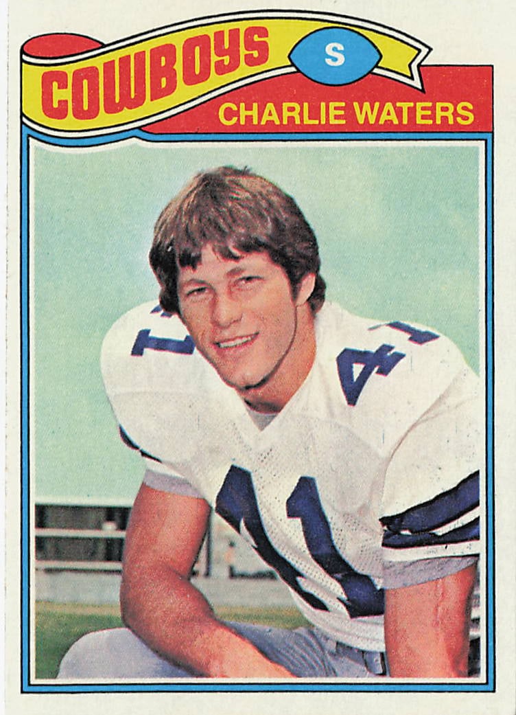 1977 Topps Charlie Waters #15 football trading card: This is a 1977 Topps football trading card featuring Charlie Waters of the Dallas Cowboys. The card highlights Waters, a standout defensive back and member of the Cowboys' famed defense, and features