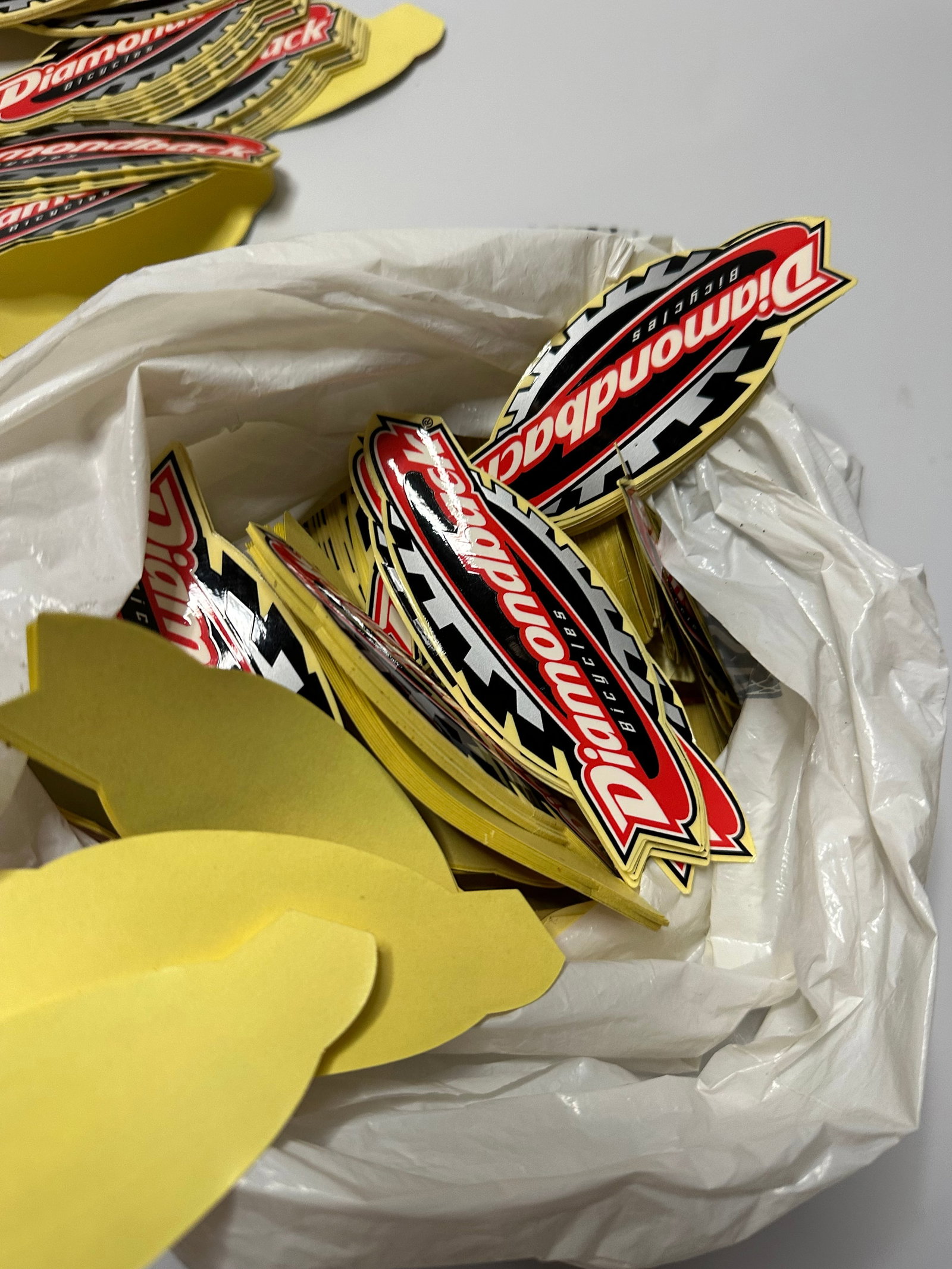 Diamondback Bicycles Stickers: This lot features a collection of multiple Diamondback Bicycles brand stickers. Each sticker has a die-cut design featuring the company name in red, white, and black text on a yellow adhesive backing.