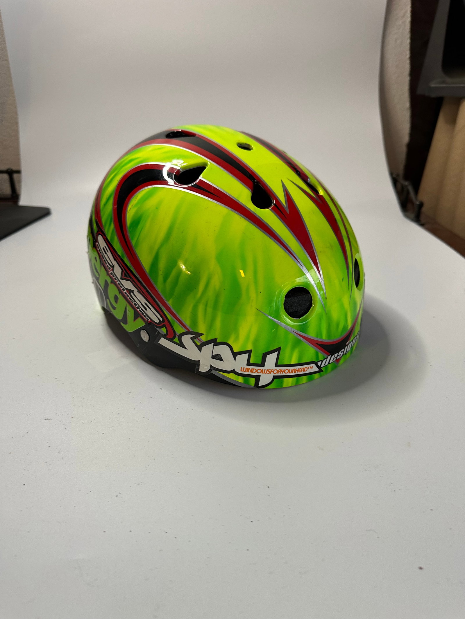 EVS Speed Protection Energy Helmet: This is an EVS Speed Protection helmet featuring a vibrant green flame pattern with black and silver detailing. The side displays 'Energy' branding along with Hansen's logo and the EVS Speed
