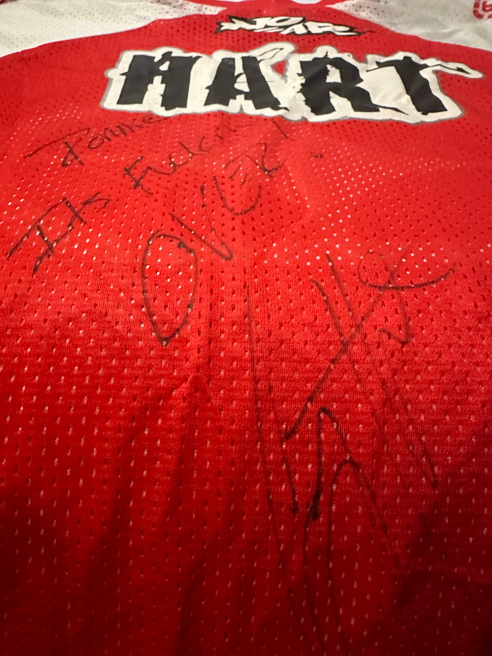 Hart Signed Jersey: This is a signed sports jersey featuring the name Hart prominently displayed on the fabric. The jersey includes a black-marker autograph, adding to its appeal as a piece of sports memorabilia.