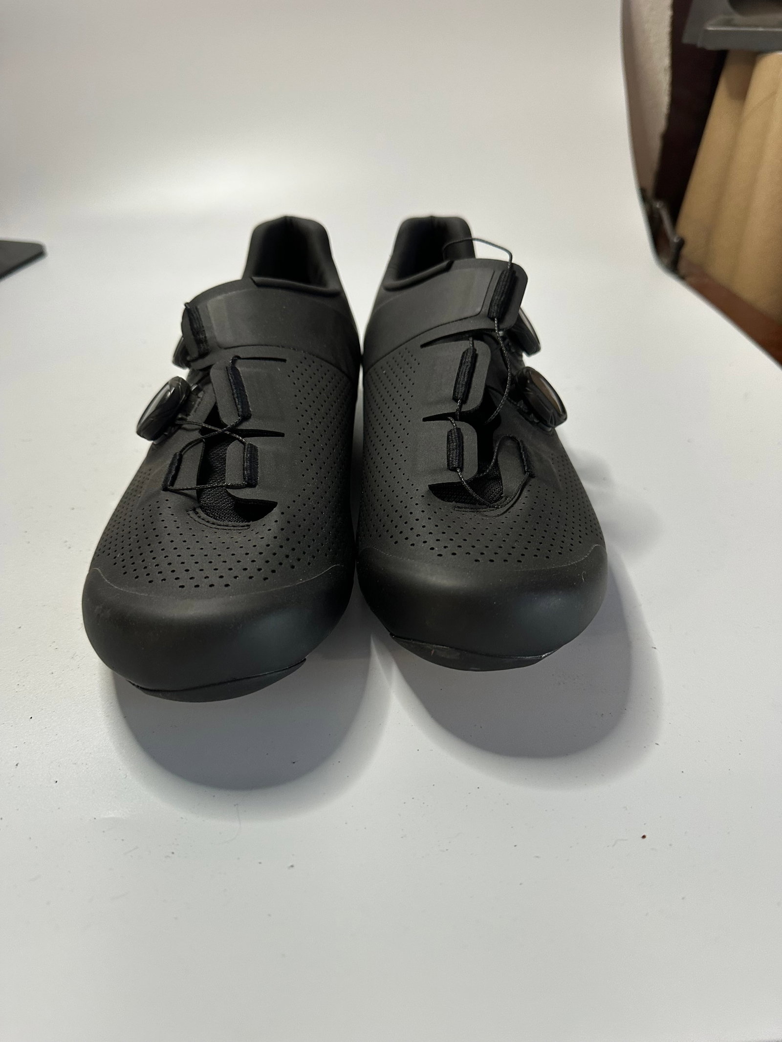 Specialized Black Cycling Shoes: A pair of black Specialized cycling shoes featuring a sleek, perforated design. The shoes are equipped with a dial-based lacing system for a secure fit.