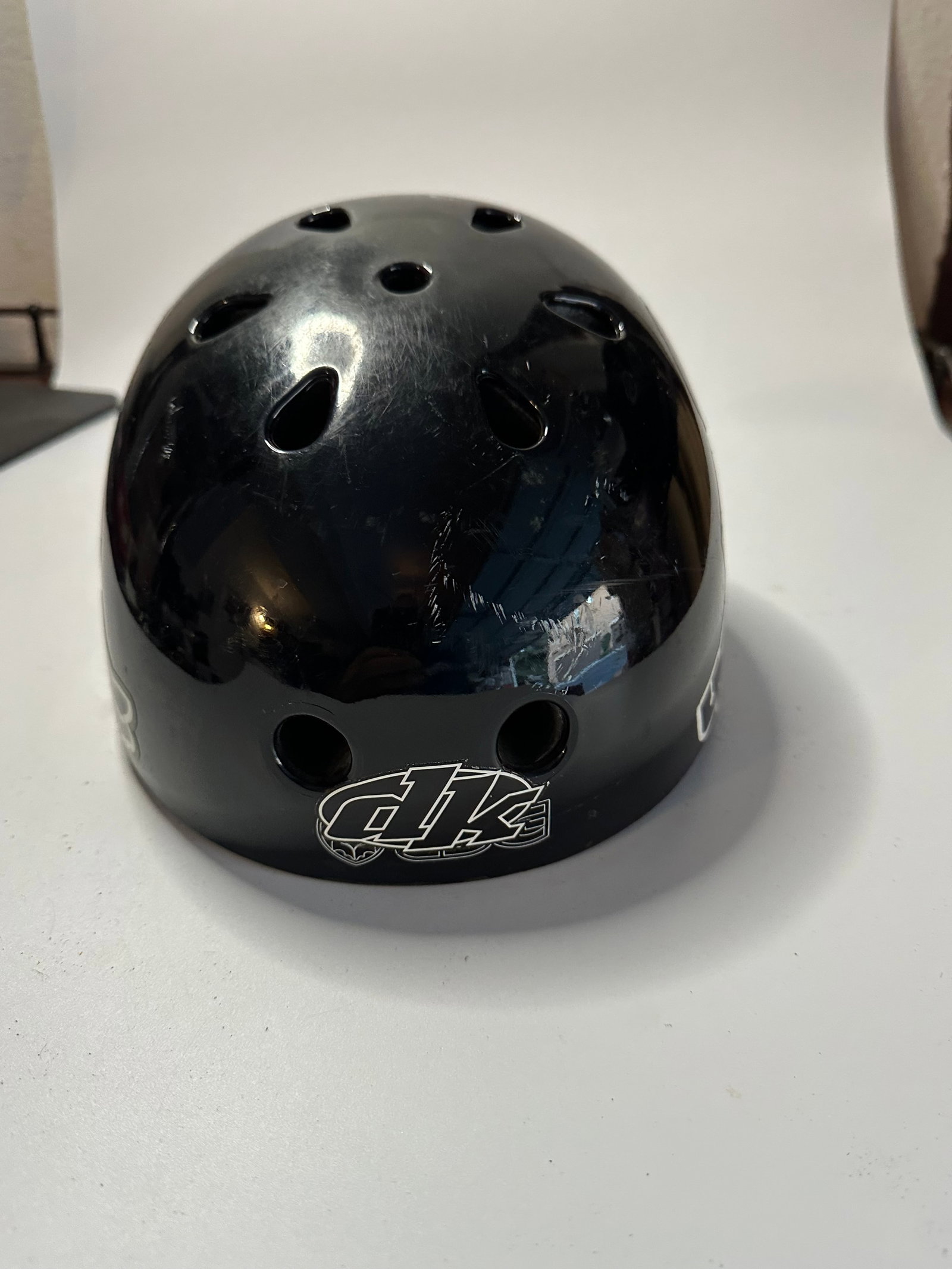 Giro Black Helmet: This is a black protective helmet featuring the Giro brand logo on the exterior. The helmet includes multiple ventilation holes and shows some surface wear and minor scratches.