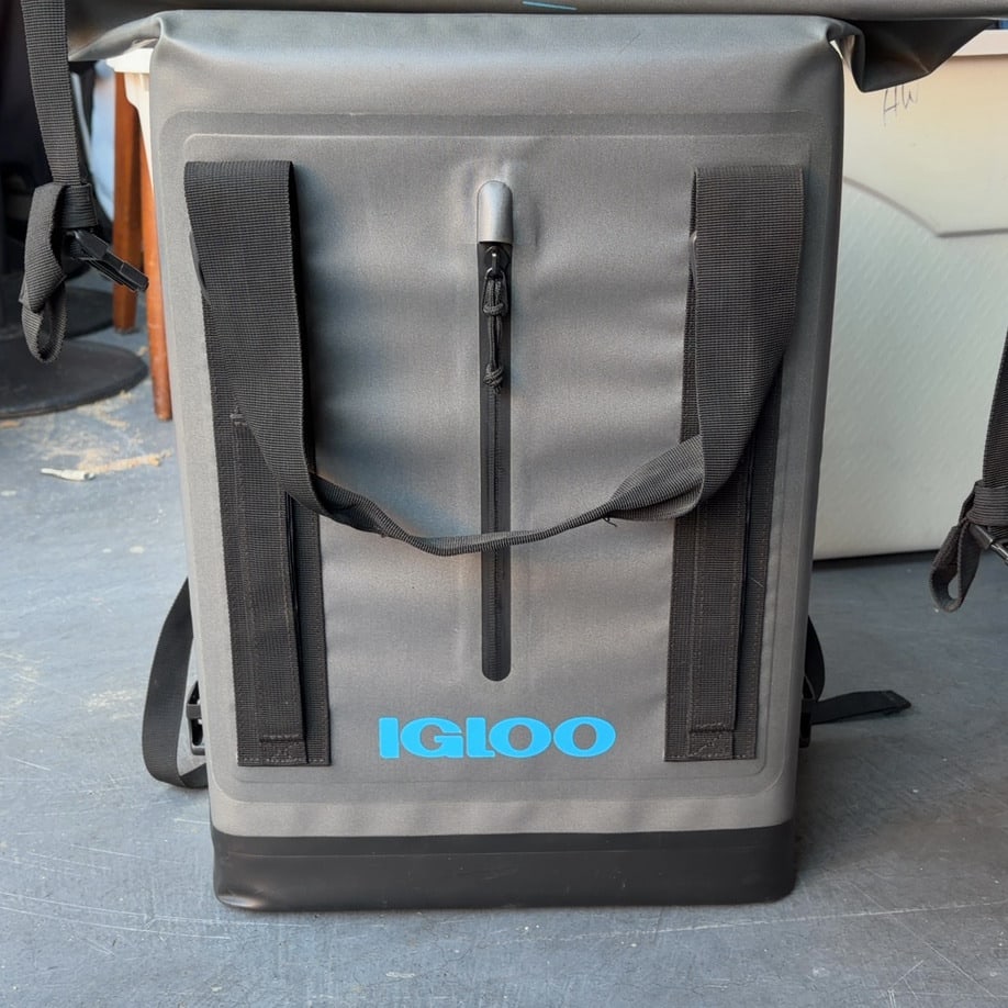 Igloo Soft Cooler Backpack: This is a grey Igloo branded soft-sided cooler backpack. It features a vertical zippered compartment on the front and adjustable straps for carrying.