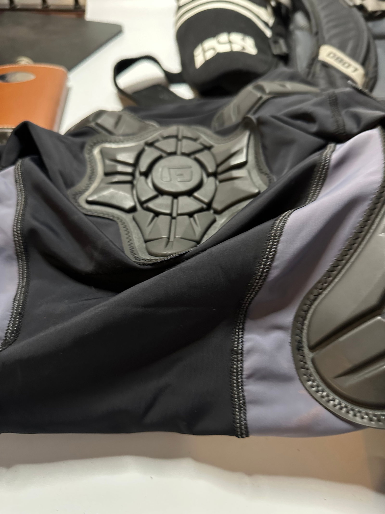 iXS Protective Gear: This is a piece of protective apparel manufactured by iXS, featuring integrated molded padding. The item includes high-impact protective zones designed for sports such as cycling or motorcycling. The