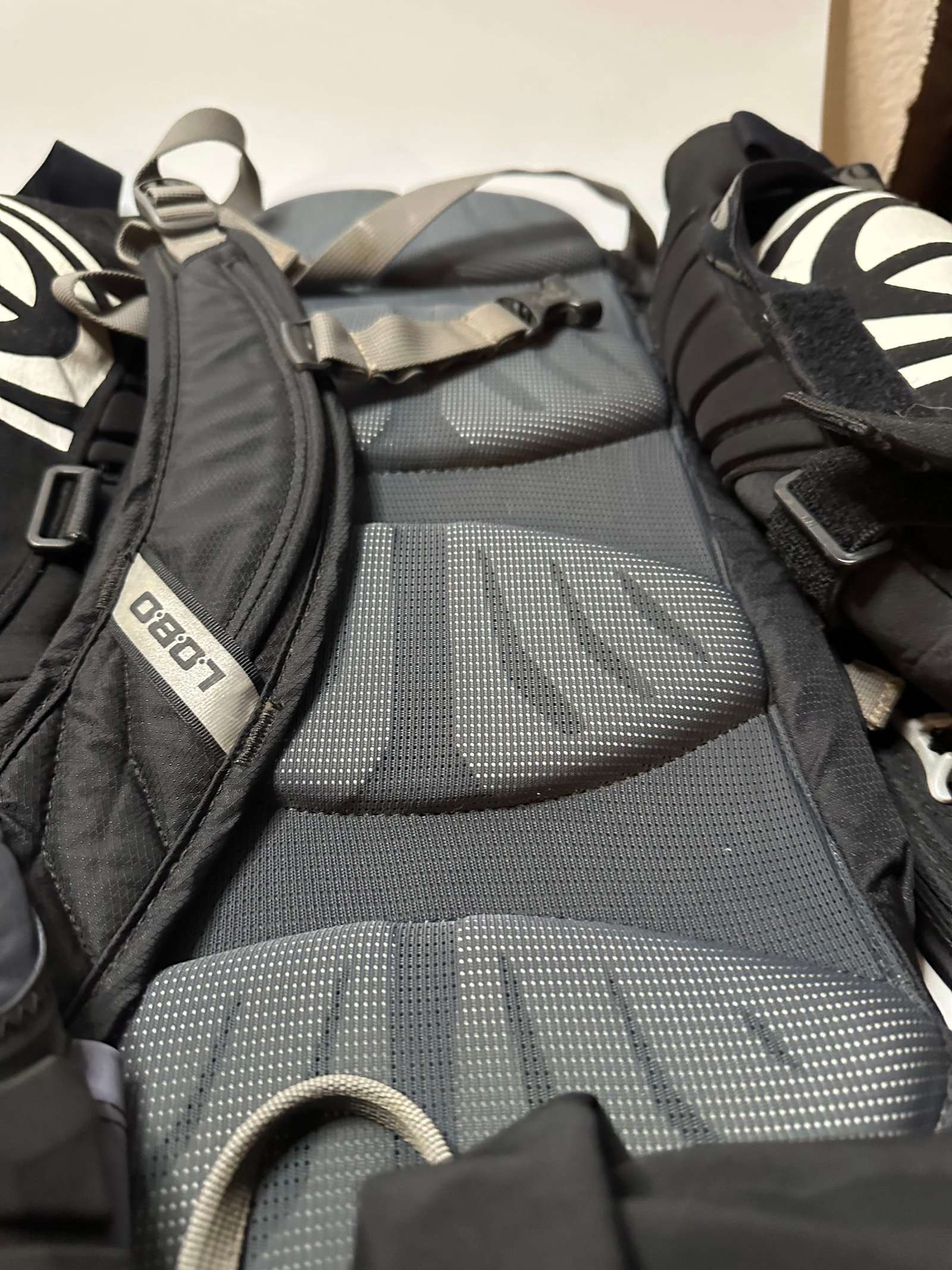 CamelBak Lobo Backpack: This is a CamelBak Lobo hydration backpack, featuring a grey and black color scheme. The design includes padded back panels and adjustable straps for comfort during outdoor activities. The CamelBak