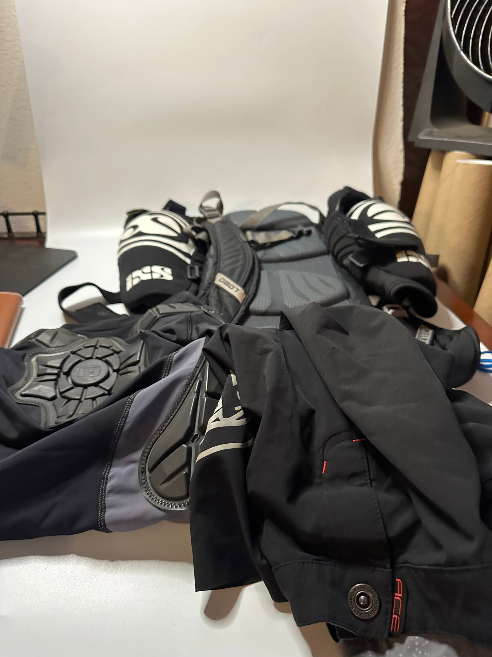 iXS Protective Gear Set: This is a collection of iXS branded protective motorcycle or cycling gear. The items include black padded garments and protective guards with clear iXS branding throughout. The pieces appear to be