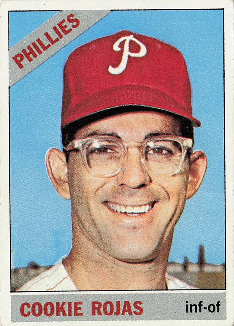 1966 Topps Cookie Rojas #440 baseball card: This vintage card captures 5-time All-Star utility specialist Cookie Rojas smiling in his signature clear-framed glasses and red cap during his tenure with the Philadelphia Phillies. True to the