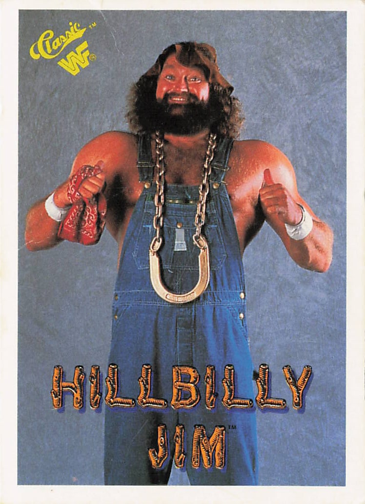 1990 Classic WWF Hillbilly Jim #20 trading card: The 1990 Classic WWF Hillbilly Jim #20 trading card features a blue, crumpled-texture border framing a studio portrait photograph of the beloved, powerhouse country fan-favorite smiling broadly while