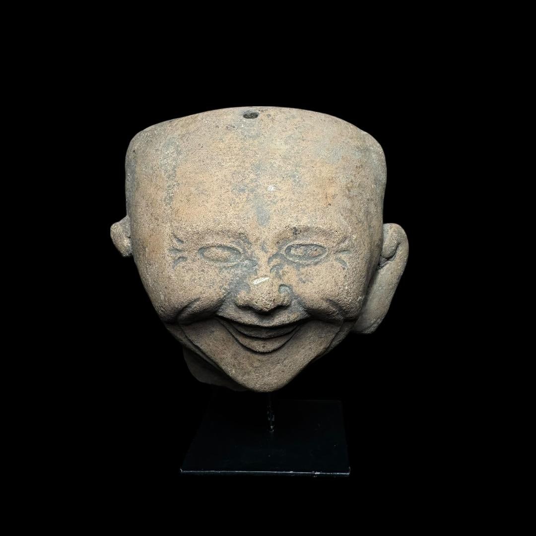 Pre-Columbian Veracruz pottery “sonriente” (smiling) head fragment: A Pre-Columbian Veracruz pottery “sonriente” (smiling) head fragment from the Gulf Coast of Mexico, dating to the Classic period (circa 600–900 AD). The fragment depicts a joyful, expressive