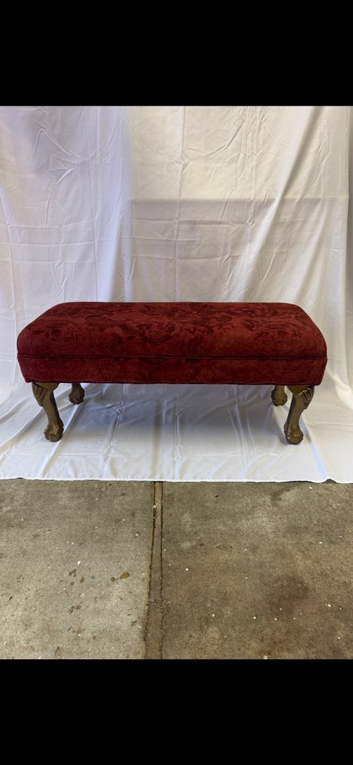 Upholstered Ottoman Bench: Long upholstered ottoman bench with carved cabriole legs with ball and claw feet. Upholstered with a red velvet fabric. These are part of the estate sale and we do not have a COA. All lots offered in 
