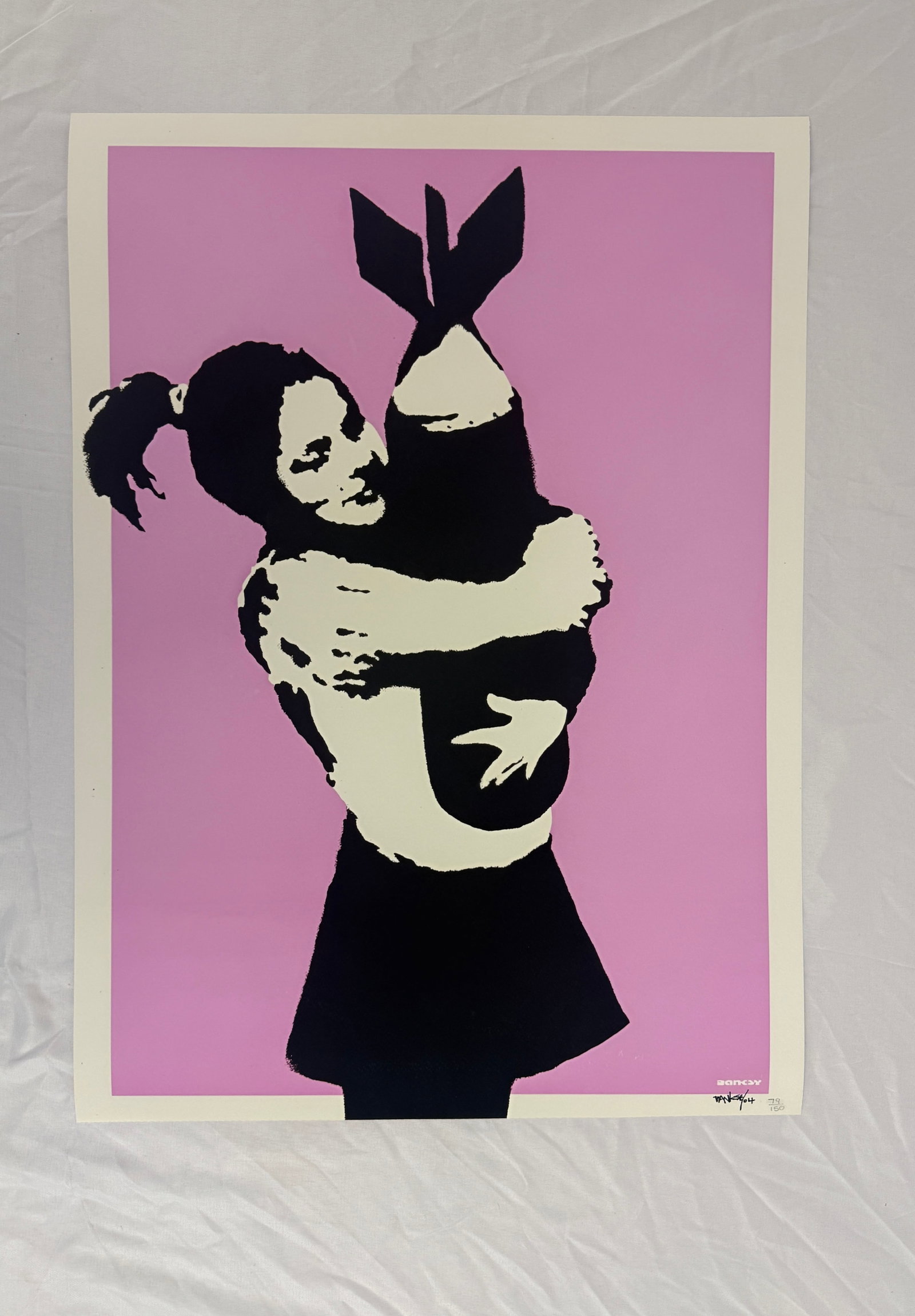 Banksy 'Bomb Love (Bomb Hugger) Print sold after: Banksy- Bomb Love (Bomb Hugger) Print on heavy wove paper. Sold after. Measures 27.5x19.75 in. These are part of the estate sale and we do not have a COA. All lots offered in our auctions are sold str