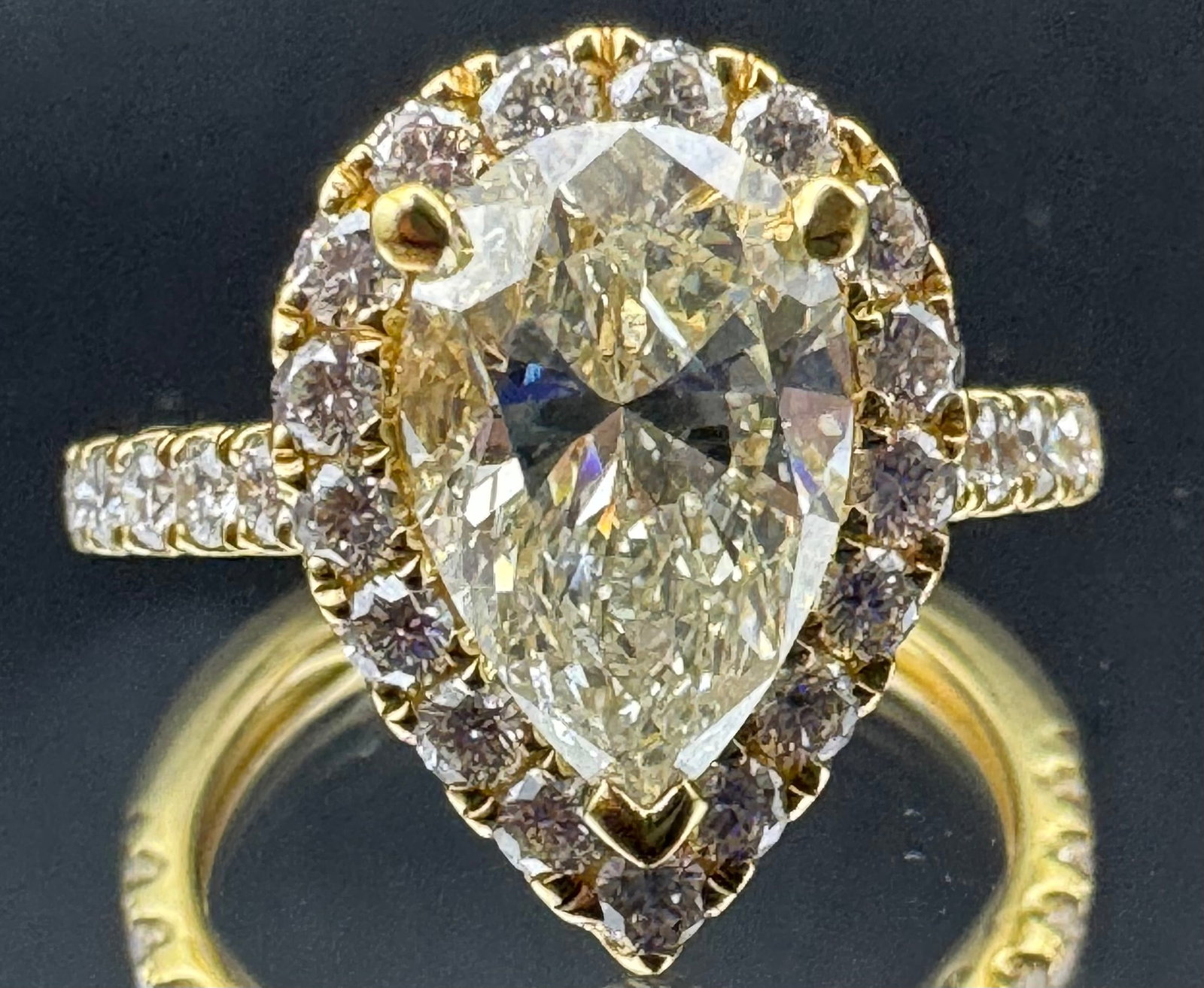 18K YELLOW GOLD 2.89 CT PEAR CUT DIAMOND RING: 18K yellow gold ring featuring a 2.09ct pear cut earth-mined diamond center stone, K/L color, VS2 clarity, set in 3 prong setting. Side stones feature 0.80ct round brilliant cut earth-mined diamonds,