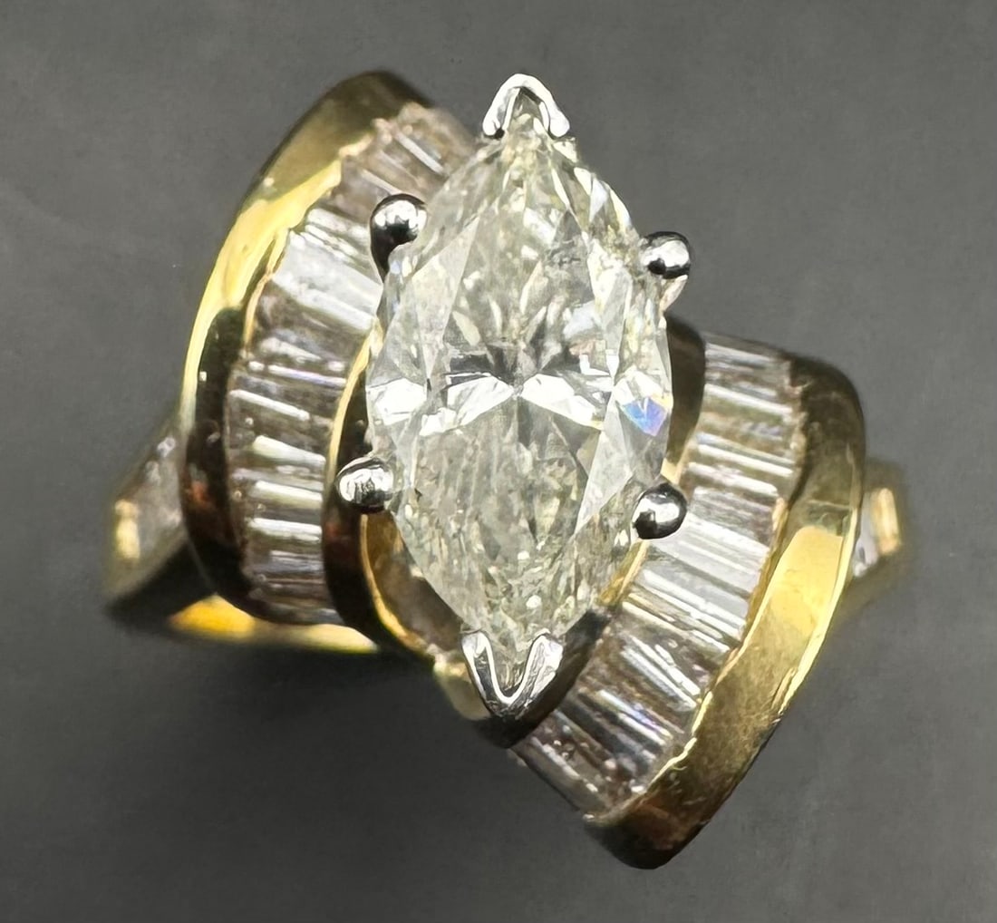 14K YELLOW GOLD MARQUISE BAGUETTE DIAMOND RING 3.85CT: 14K yellow gold ring featuring a 2.20ct marquise cut earth-mined diamond center stone, H/I color, SI2/I1 clarity, set in 6 prong setting. Side stones feature 1.65ct baguette cut earth-mined diamonds,