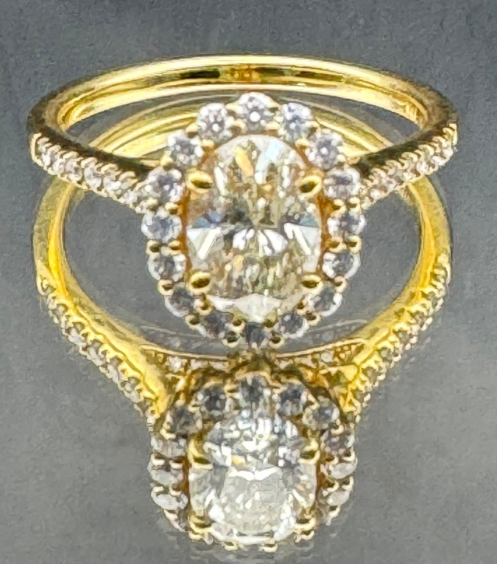18K YELLOW GOLD OVAL CUT DIAMOND RING 1.67CT: 18K yellow gold ring featuring a 1.07ct oval cut earth-mined diamond center stone, J/K color, SI1 enhanced clarity, set in 4 prong setting. Side stones feature 0.60ct round brilliant cut earth-mined d