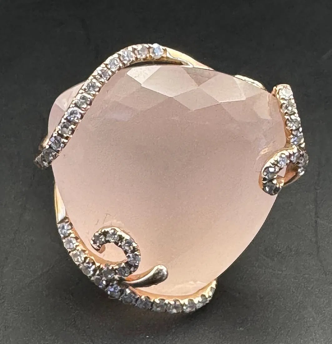 14K ROSE GOLD ROSE QUARTZ DIAMOND RING 16CT QUARTZ 0.20CT DIAMOND: 14K rose gold ring featuring a 16ct rose quartz center stone set in designer prong setting. Accompanied by 0.20ct round brilliant cut diamonds, G-H color, VS clarity, set in prong setting. Total ring