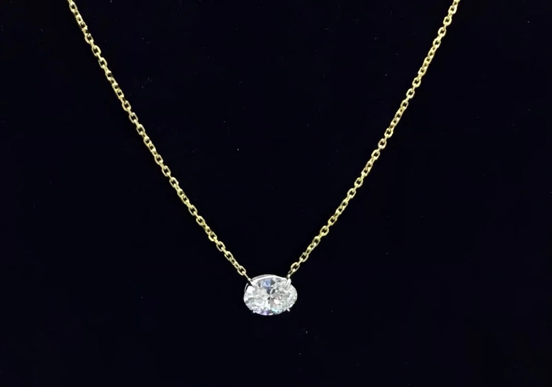 14K TWO-TONE GOLD LAB DIAMOND OVAL PENDANT NECKLACE 1.57CT: 14K two-tone gold pendant necklace featuring a 1.57ct oval cut lab-grown diamond, E color, VS1 clarity, set in white gold prong setting. Pendant hangs from 14K yellow gold chain, 16 inches long. Total