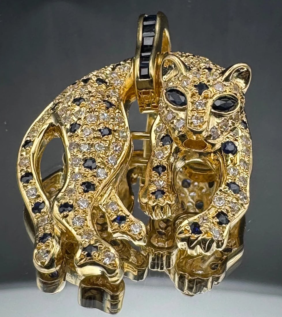 18K YELLOW GOLD 3D PANTHER PENDANT/PIN SWAROVSKI SAPPHIRE: 18K yellow gold 3D panther pendant featuring Swarovski crystals body and sapphire eyes. Total pendant weight 16.4 grams. Stamped 18K. New condition. Item can be appraised upon request. Please review a