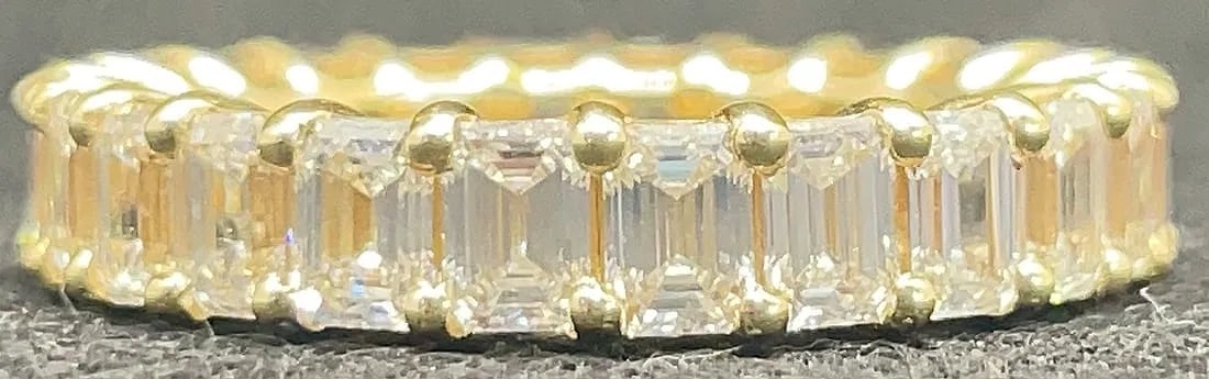 18K YELLOW GOLD EMERALD CUT EARTH-MINED DIAMOND ETERNITY BAND 4.00CT: 18K yellow gold eternity band featuring 4.00ct emerald cut earth-mined diamonds, G-H color, VS1/VS2 clarity, vertically set in eternity setting throughout. High polish finish. Total ring weight 4.3 gr