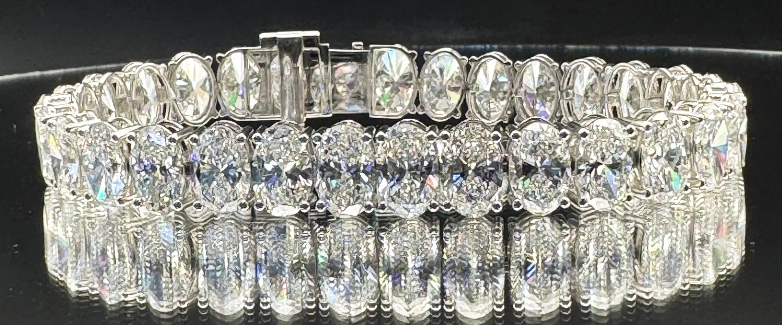 31.91CTW OVAL LAB-GROWN DIAMOND TENNIS BRACELET 14K WHITE GOLD: An extraordinary 14K white gold tennis bracelet featuring 30 magnificent oval-cut lab-grown diamonds totaling a massive 31.91 carats. These exceptional stones boast E-F color and VS clarity, providing
