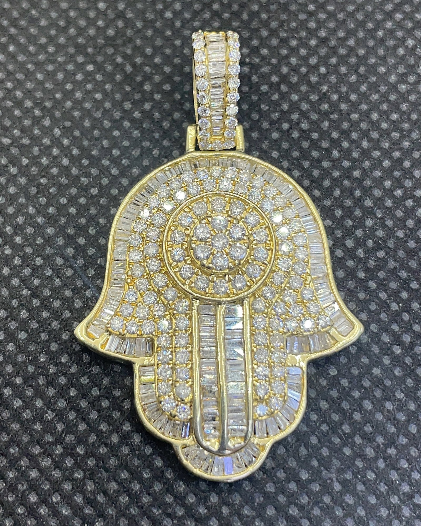 14k Yellow Gold 2.50ctw Round & Baguette Diamond Hamsa Pendant (8.3g): This striking Hamsa-inspired pendant features an intricate abstract hand design radiant with 2.50 carats total weight of round and baguette-cut diamonds. The 100% earth-mined diamonds are meticulously