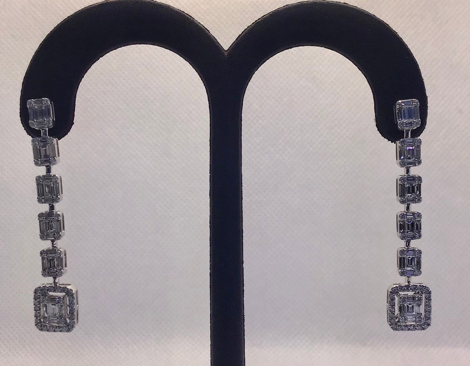 18k White Gold 2.00ctw Mixed-Cut Diamond Baguette Vertical Drop Earrings (6.7g): These gorgeous and stylish 18k white gold earrings deliver an unforgettable look with a custom-designed vertical silhouette. The graceful dangle design features a sophisticated mix of natural earth-mi