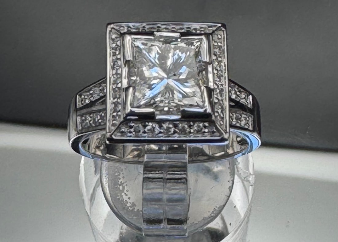14K WHITE GOLD 2.21CTW PRINCESS CUT DIAMOND RING: Hand-made 14K white gold ring featuring a 1.81-carat princess-cut earth-mined diamond center stone. The center diamond is EGL certified with clarity enhancement. The mounting is accented with 0.40 car