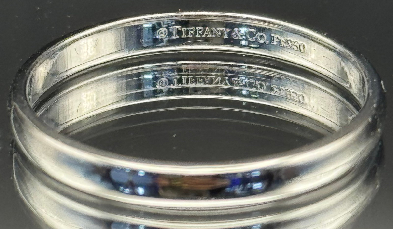Tiffany & Co. Classic Platinum Wedding Band: Exude class with this authentic Tiffany & Co. wedding band. Crafted in solid 950 platinum, this piece features a high-polished domed design. Stamped "©Tiffany & Co. PT950" on the interior. Currently 