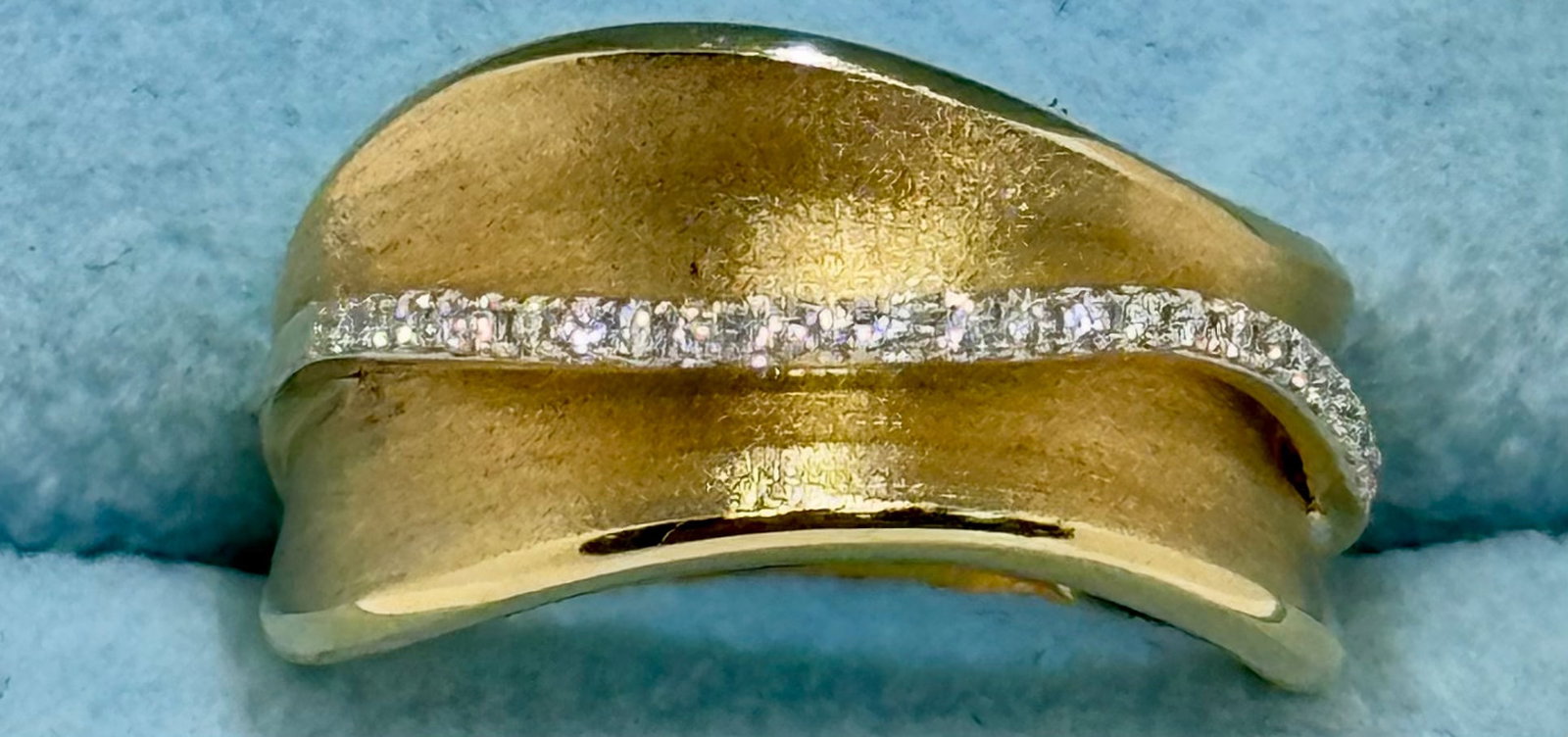 Modern 14k Yellow Gold "Wave" Pave Diamond Ring: This stunning 14k yellow gold ring features a wide, fluid "wave" silhouette with a luxurious brushed matte finish. Intersecting the band is a sleek, polished ribbon meticulously pave-set with 0.25 car