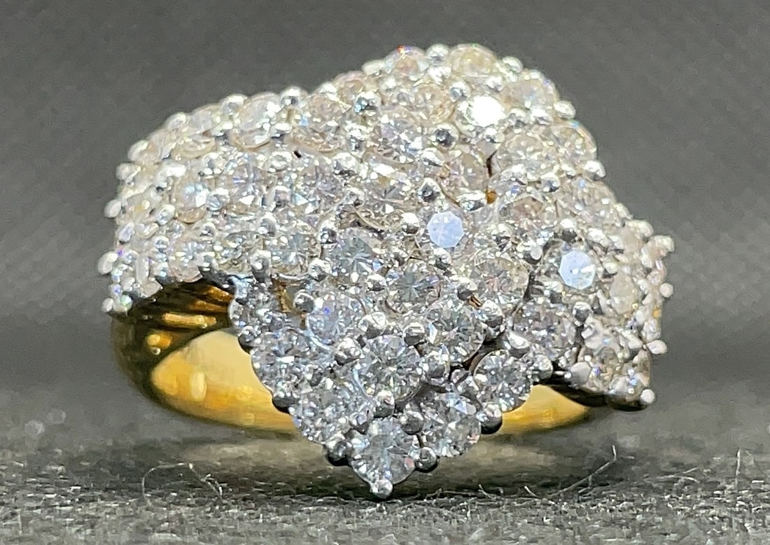 18k Two-Tone Gold 2.80ctw Round Brilliant Diamond Crossover Ring (10.3g): This delightful crossover-style ring is designed to showcase a bright and vibrant personality through a magnificent cluster arrangement. Meticulously handcrafted in sunny 18k yellow gold, the ring fea