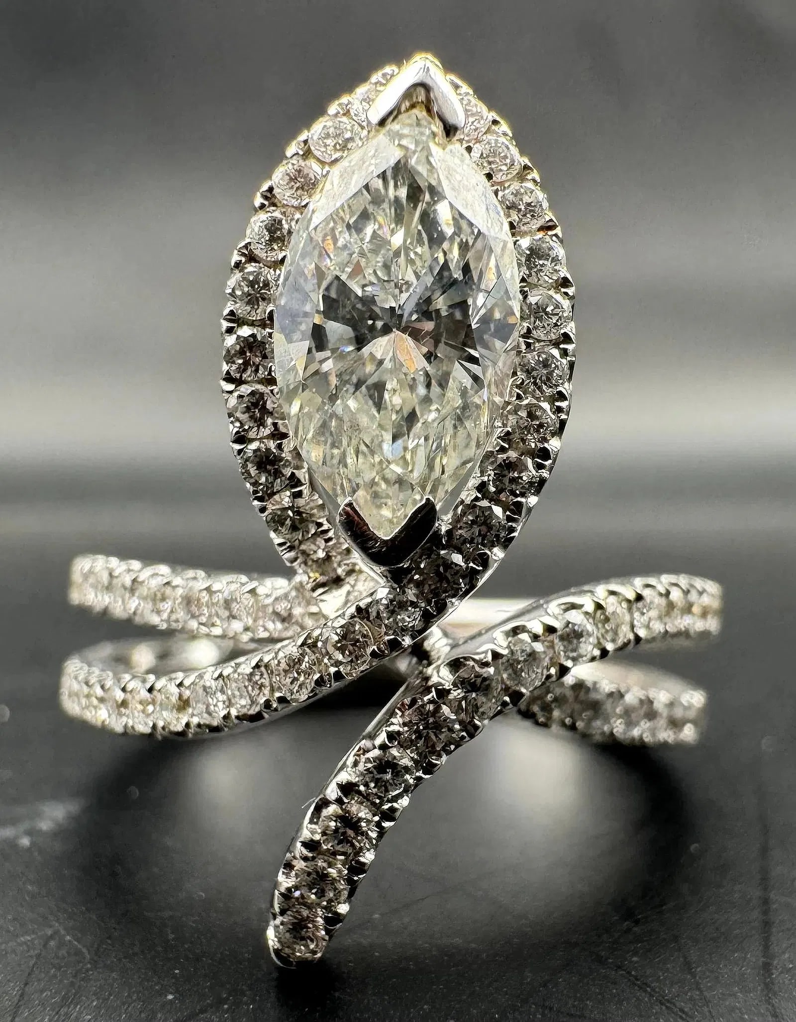 18K WHITE GOLD MARQUISE CUT EARTH-MINED DIAMOND RING 1.60CT: 18K white gold ring featuring a 1.00ct marquise cut earth-mined diamond center stone, G color, VS2/SI1 clarity, set in 2 prong setting. Side stones feature 0.60ct round brilliant cut earth-mined diamo