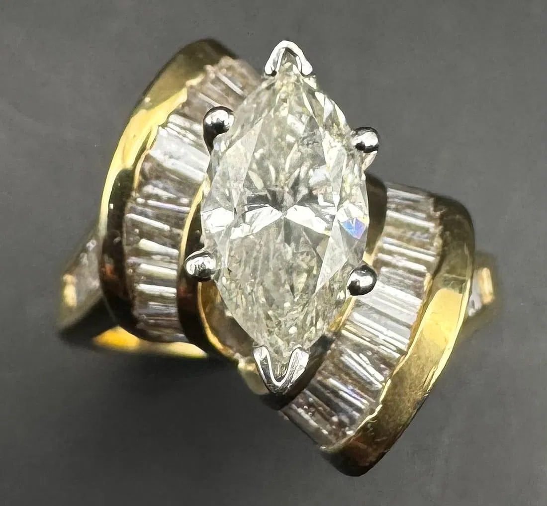 14K YELLOW GOLD MARQUISE BAGUETTE DIAMOND RING 3.85CT: 14K yellow gold ring featuring a 2.20ct marquise cut earth-mined diamond center stone, H/I color, SI2/I1 clarity, set in 6 prong setting. Side stones feature 1.65ct baguette cut earth-mined diamonds, 