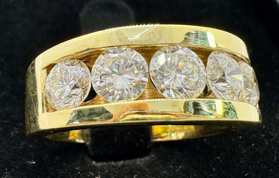 14K YELLOW GOLD 2.25CTW ROUND DIAMOND CHANNEL SET RING: An impressive and substantial 14K yellow gold statement ring featuring 2.25 carats of round brilliant cut diamonds. The diamonds are expertly secured in a seamless channel setting, boasting exceptiona