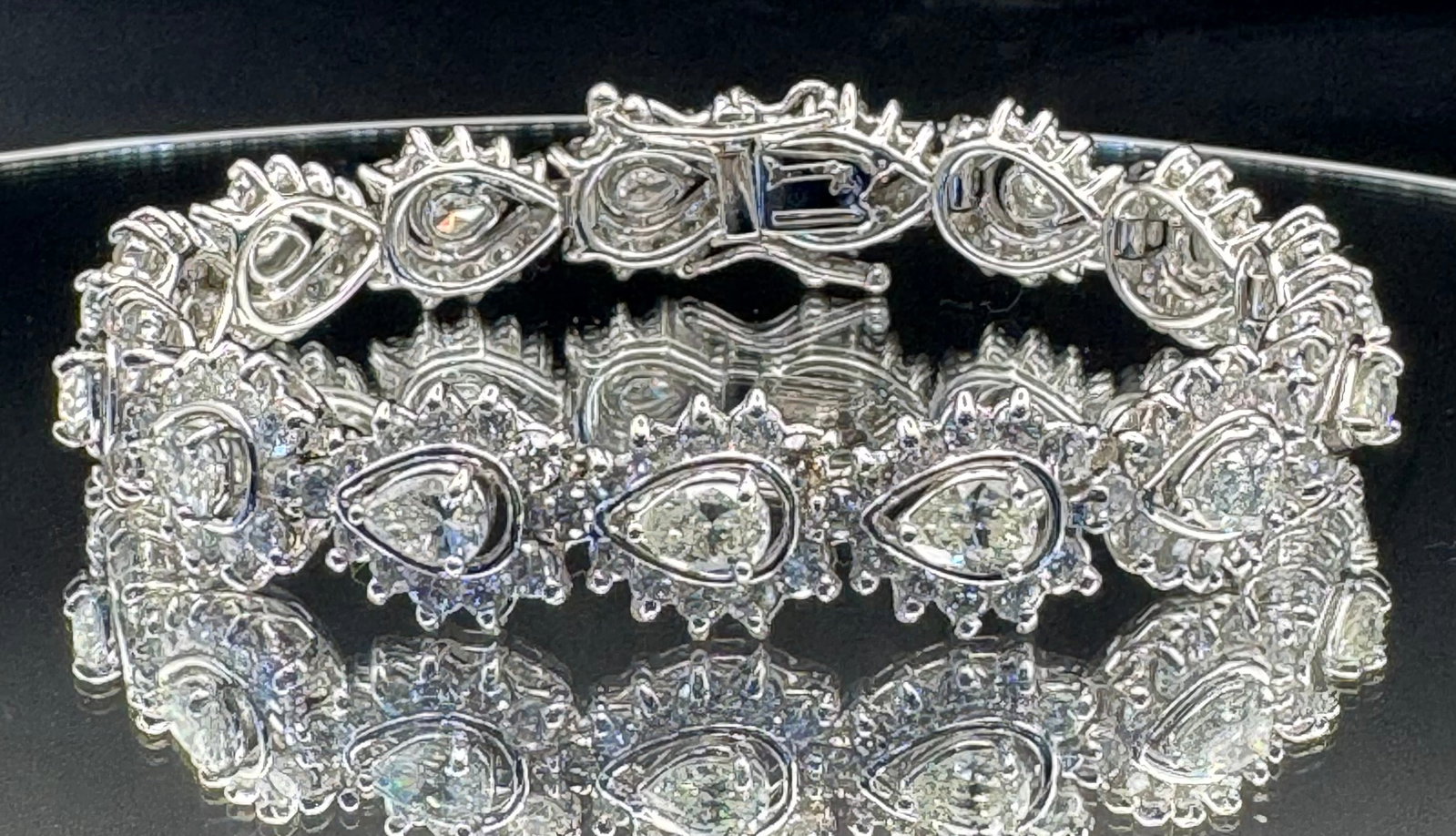 18.50CTW PEAR & ROUND DIAMOND TENNIS BRACELET 14K WHITE GOLD (30.37G): An architectural masterpiece in fine jewelry, this 14K white gold tennis bracelet features a staggering 18.50 total carats of earth-mined diamonds. The unique design showcases 15 magnificent pear-cut 