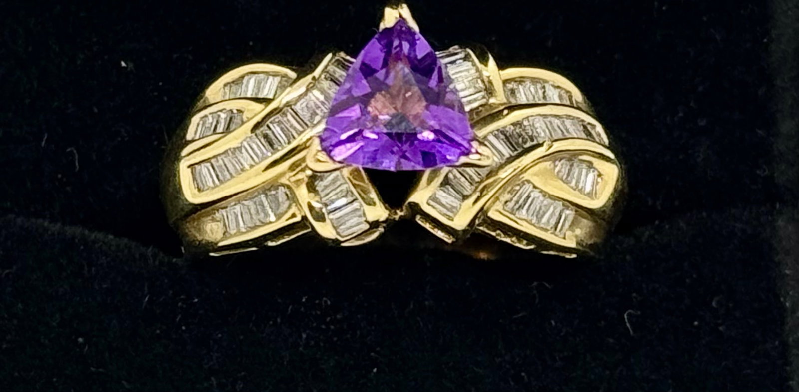 1.50ct Trillion Cut Amethyst & 1.10ctw Natural Diamond Ring | 14k Gold (8.4g): This striking 14k yellow gold ring features a 1.50-carat trillion-cut (tri-cut) natural amethyst, secured in a traditional prong setting. The central gemstone is beautifully framed by 1.10 carats of n