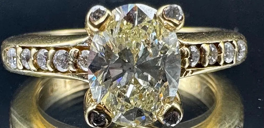14K YELLOW GOLD OVAL CUT DIAMOND RING 2.05CT: 14K yellow gold ring featuring a 1.75ct oval cut earth-mined diamond center stone, J/K color, VS1 enhanced clarity, set in four bezel prong setting. Side stones feature 0.30ct round brilliant cut eart