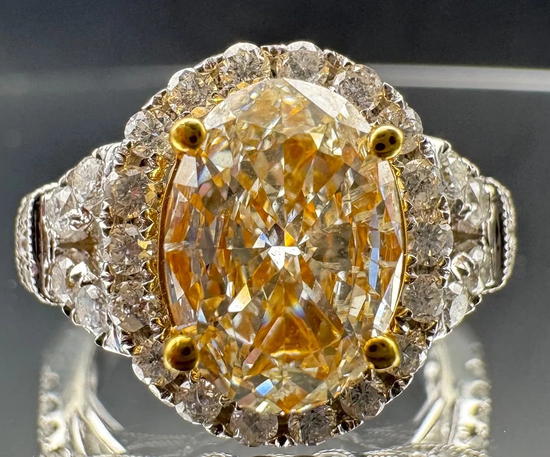 14K TWO-TONE GOLD FANCY YELLOW OVAL CUT DIAMOND RING 2.51CT: Beautiful 14K two-tone gold ring featuring a 1.66ct oval cut earth-mined diamond center stone, light fancy yellow color, VS2/SI1 clarity, set in 4 prong setting. Side stones feature 0.85ct round brill
