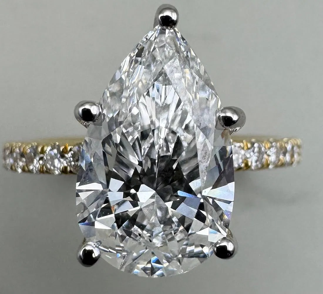 14K TWO-TONE GOLD LAB DIAMOND PEAR CUT RING IGI CERTIFIED 2.95CT: 14K two-tone gold ring featuring a 2.60ct pear cut lab-grown diamond center stone, E color, VS1 clarity, IGI certified, set in 5 prong setting. Side stones feature 0.35ct round brilliant cut lab-grown