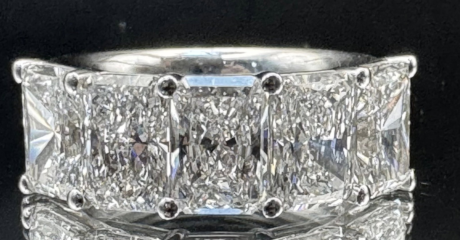14K WHITE GOLD 5.50CTW RADIANT CUT LAB GROWN DIAMOND RIN: 14K white gold ring featuring a five-stone design with a total weight of 5.50 carats. Each lab-grown radiant cut diamond is set in a classic four-prong mounting. The diamonds boast exceptional E color