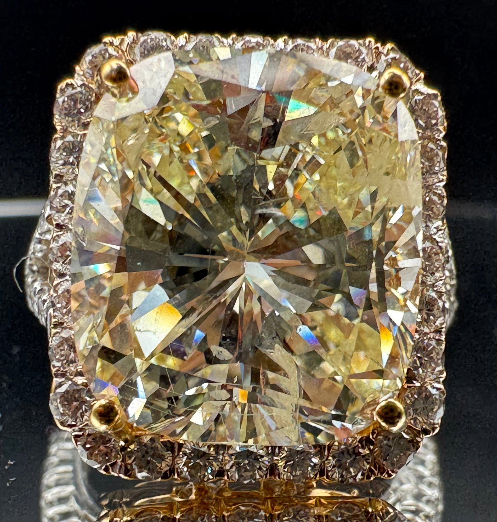 18K TWO-TONE GOLD 14.14CTW CUSHION CUT DIAMOND RING: Exquisite 18K two-tone gold ring featuring a massive 12.59-carat cushion-cut earth-mined diamond center stone. The center diamond is L color with SI1/SI2 clarity (enhanced). The mounting is further ac